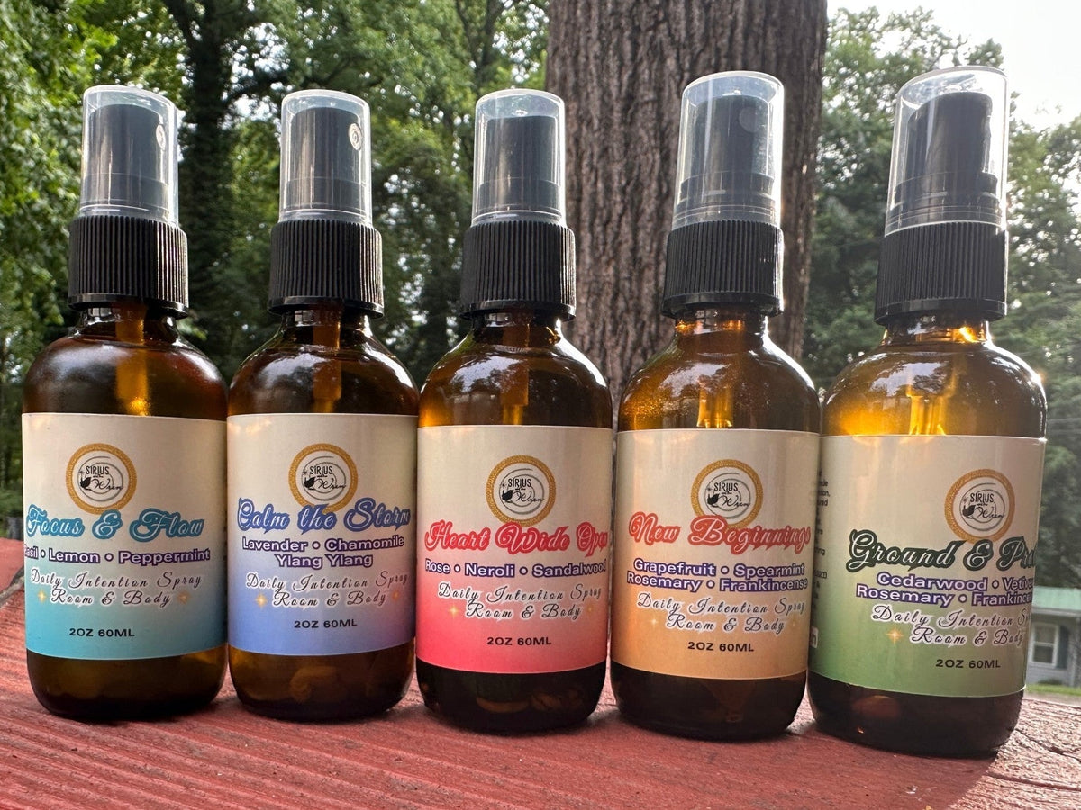 All of the 2 oz Daily Intention Sprays together on a wooden surface with a natural background