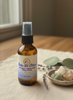 Calm the Storm Daily Intention Spray, 2 oz, on a textured surface with a bowl of stones and leaves