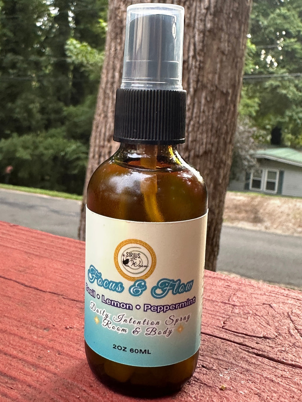 Focus + Flow Daily Intention Spray, 2 oz, on a wooden surface outdoors
