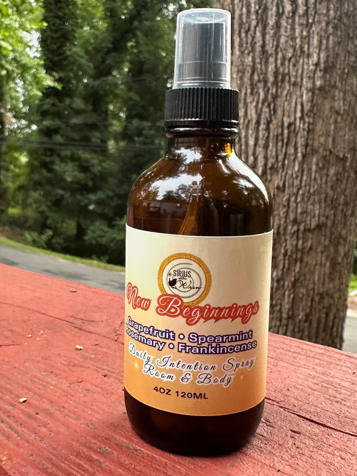 New Beginnings Daily Intention Spray, 4 oz, on a wooden surface outdoors