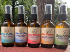 All of the 2 oz Daily Intention Sprays together on a wooden surface with a natural background