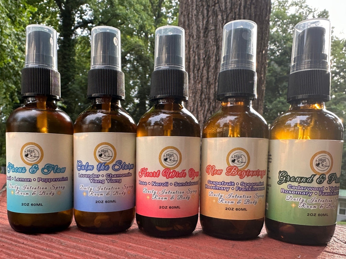 All of the 2 oz Daily Intention Sprays together on a wooden surface with a natural background