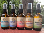 All of the 2 oz Daily Intention Sprays together on a wooden surface with a natural background