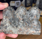 A Yooperlite See No Evil, Hear No Evil, Speak No Evil Carving - 402 g, crafted from grey and brown speckled stone into three skulls depicting the classic poses.