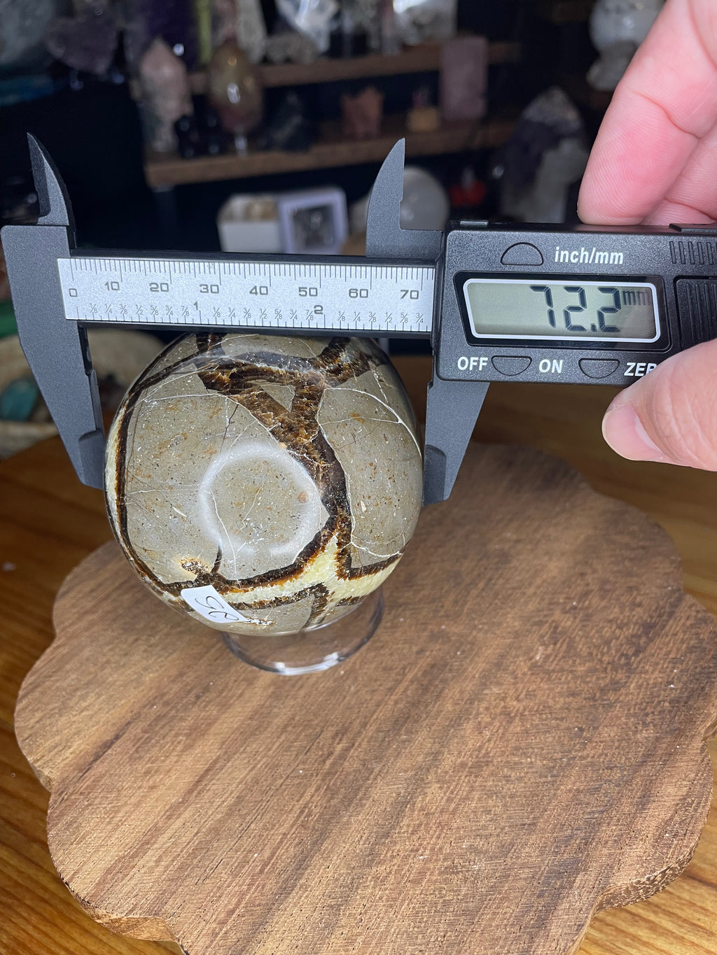 A Big Mama Septarian Egg - UV Reactive - 22.9 oz sphere being measured with digital calipers, showing a diameter of 72.2 millimeters.